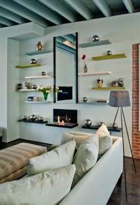 ELIZABETH BUTLER INTERIORS CLOSE-UP OF LIBRARY WALL WITH TOM DIXON TRIPOD LAMP